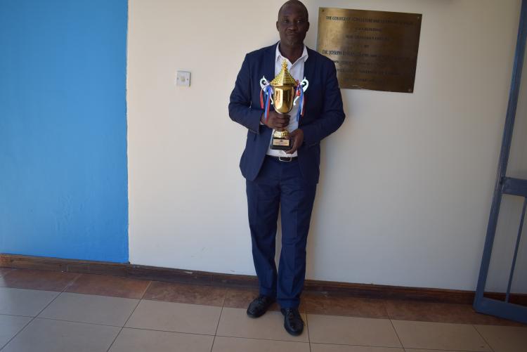 Dr. Evans Chimoita  with a Trophy as the Best Teacher in the Faculty of Agriculture